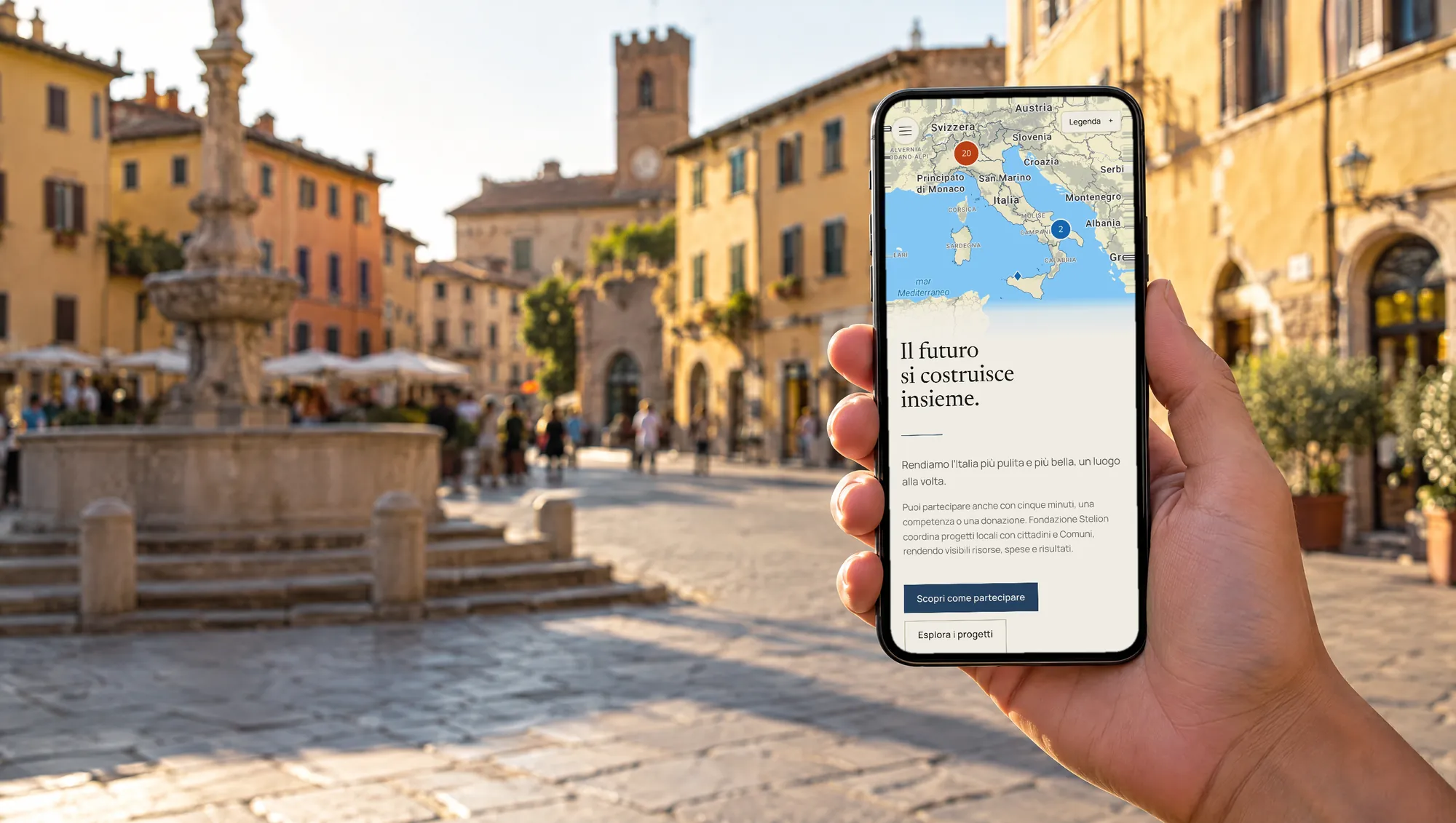 Il sito di Fondazione Stelion su un telefono tenuto in mano in una piazza storica